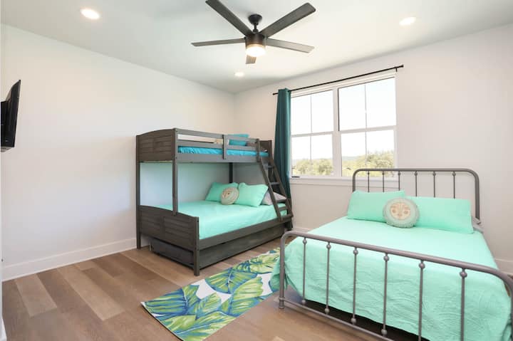 Оваа шармантна спална соба има кревет на спрат, рамен кревет, полн кревет и светол, привлечен простор со природна светлина.