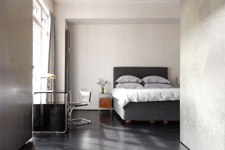 Stadtflucht berlin 411 მინიმალისტური საძინებელი შავი იატაკი ბუნებრივი განათება თანამედროვე დეკორი მშვიდი სივრცე