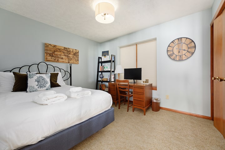 Ოთახი განათებულია ღია ცისფერი კედლებით და აქვს ხის ფრანგული კარები სარკეებით, ხის სამუშაო მაგიდით და მსოფლიო რუკის კედლის ხელოვნებით, რაც ქმნის თბილ და მიმზიდველ ატმოსფეროს.