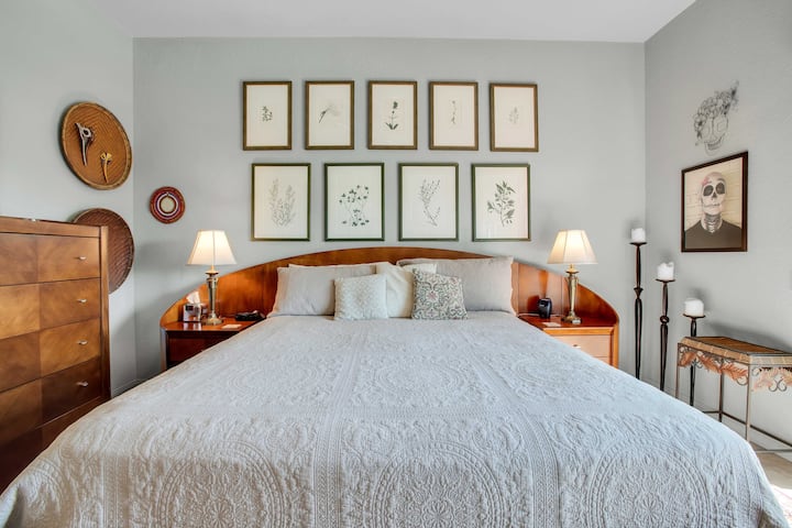 غرفة نوم أساسية هادئة مع سرير كينج وديكور على طراز بالم سبرينغز