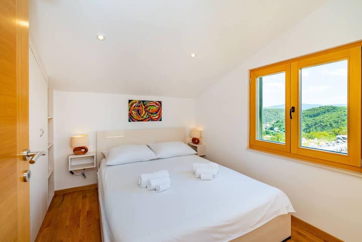 Bedroom with queen bed and a view.
