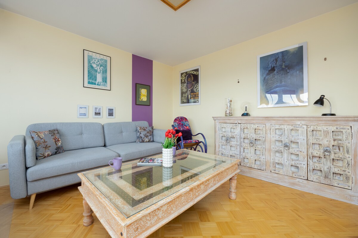 Удобен простор во дневната соба со кауч, фотелја, масичка за кафе и комода со украси. Совршено за опуштање или поминување време со вашите сакани.