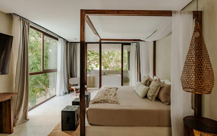 A king bedroom with a canopy frame and soft linens for a restful night's sleep.
