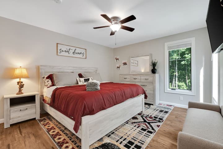 Dormitorio principal con una cama tamaño king y un televisor Roku