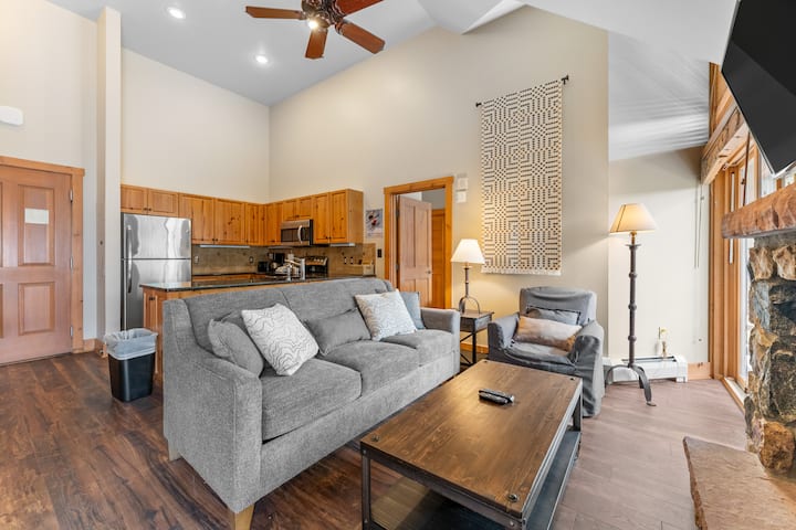 Sala de estar con techos abovedados y TV de pantalla plana