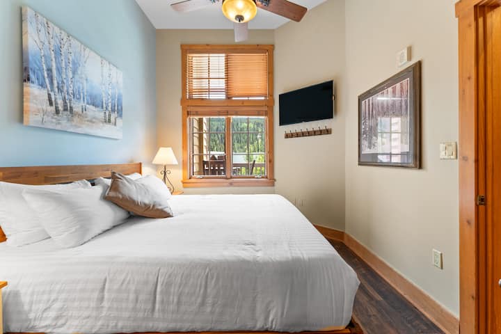 Dormitorio con cama tamaño king y TV de pantalla plana