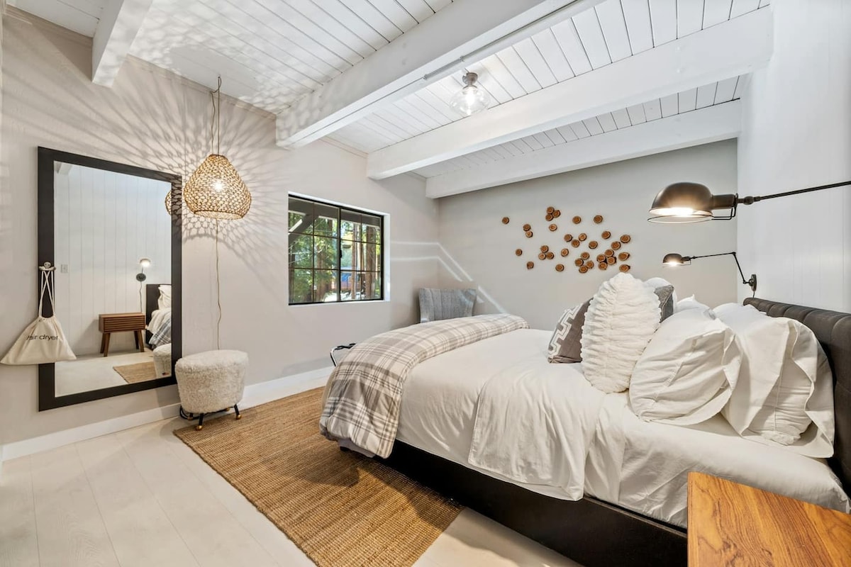 A bright and welcoming space with a king bed and a connection to nature through its windows.