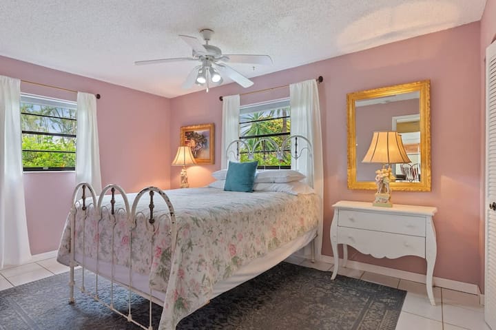 Letto matrimoniale in ferro con ampio armadio e cassettiera (non mostrato) con vista sui giardini. Smart HDTV da 49"