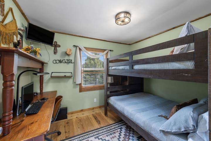 שני מזרנים בגודל מלא על מיטת הקומתיים הזו עם פינת עבודה וטלוויזיה