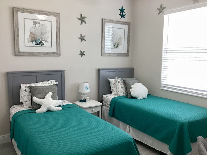Twin Bedroom: Bright coastal decor, charming sea-inspired accents, and inviting beds await!