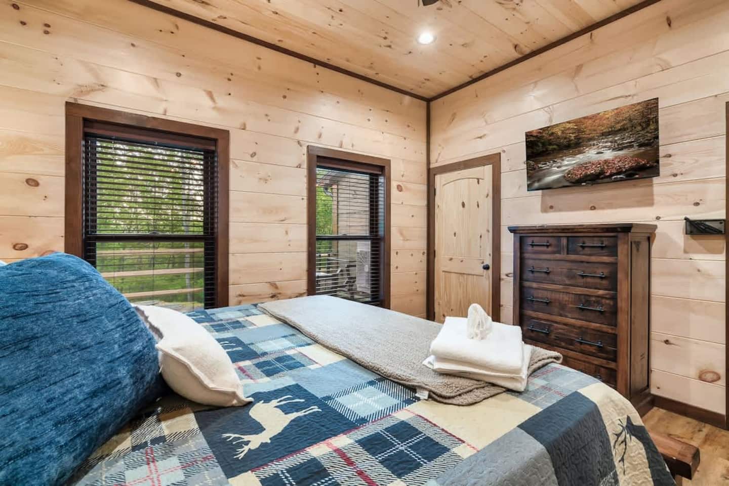 King Suite 3 — basement level, deer-print quilt, deck and forest view