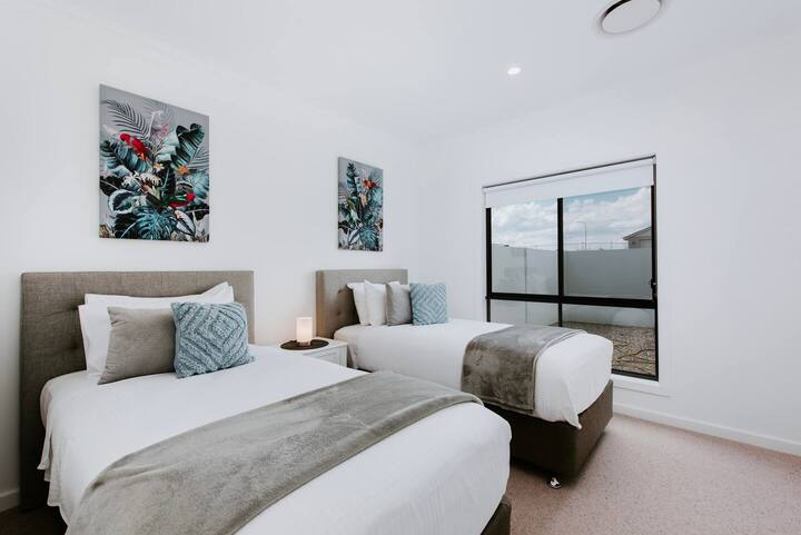  Ორი ერთადგილიანი საწოლი ქმნის იდეალურ წყვილს მეხუთე საძინებელში ნაცრისფერი და ლურჯი ფერებით.