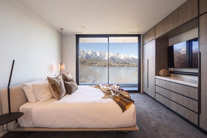 Camera da letto 5 con letto matrimoniale grande, accesso al balcone e vista sui monti The Remarkables