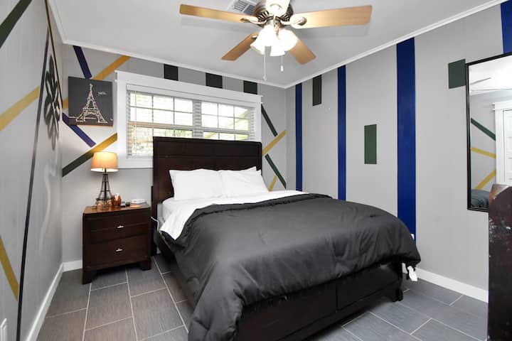 Ruime slaapkamer met queensize bed, tv, plafondventilator, 
en zachte verlichting voor een rustgevende sfeer. Voldoende opbergruimte, hangers, 
en een strakke indeling zorgen voor comfort. Elke slaapkamer heeft een eigen slot 
voor privacy - ideaal om te ontspannen na het verkennen of werken.