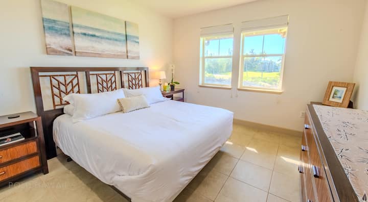 חדר שינה ראשי עם נוף לים וטלוויזיה חכמה.