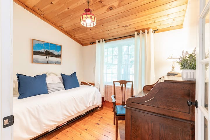 Dormitorio cómodo con una cama doble y una cama nido, además de un espacio de trabajo dedicado.