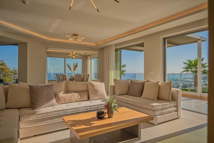 Dhoma e ndenjjes e rrethuar nga tekstura të ngrohta dhe ndenjëse të buta dhe elegante.