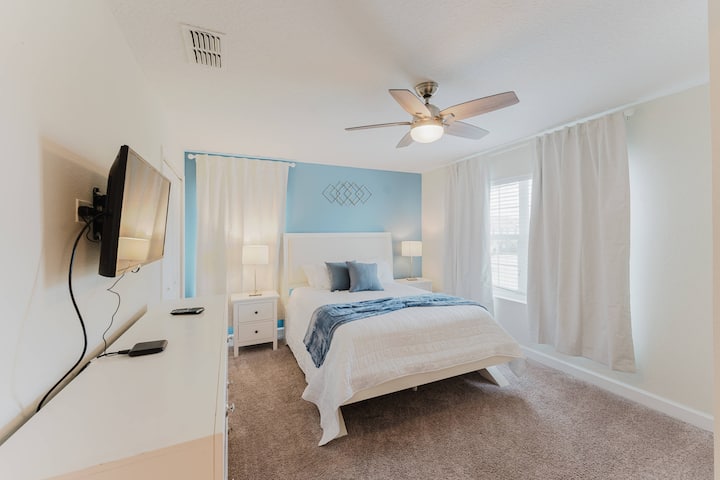 Zažite pokoj v tejto útulnej spálni s mäkkým béžovým kobercom a upokojujúcou modrou stenou. Štýlový biely nábytok vrátane mäkkej postele a elegantných nočných stolíkov umocňuje pokojnú atmosféru vytvorenú prirodzeným svetlom.