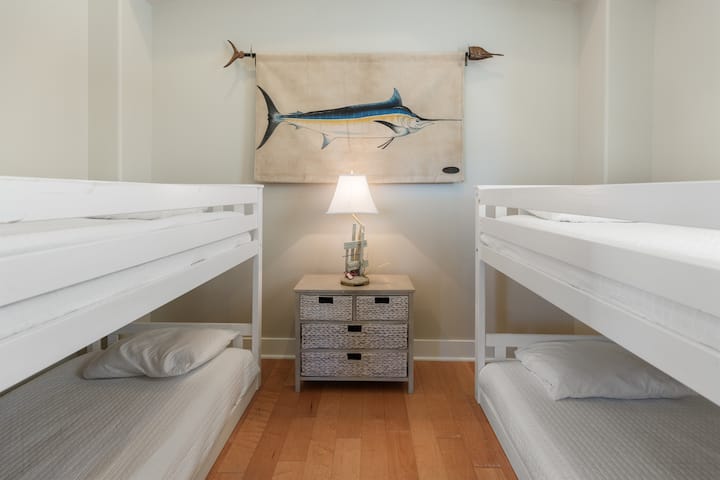 Hyggeligt køjesovekammer med friskt, hvidt sengetøj og maritim charme, perfekt til din gruppes afslappende nætter sammen.