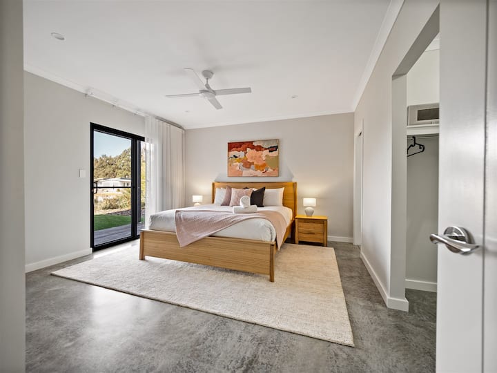 La espaciosa suite principal está equipada con una cama tamaño king, bata a ras de suelo y baño privado.