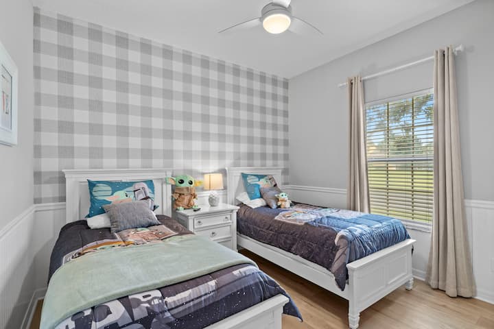 Dormitorio #2: planta baja con camas individuales y TV
