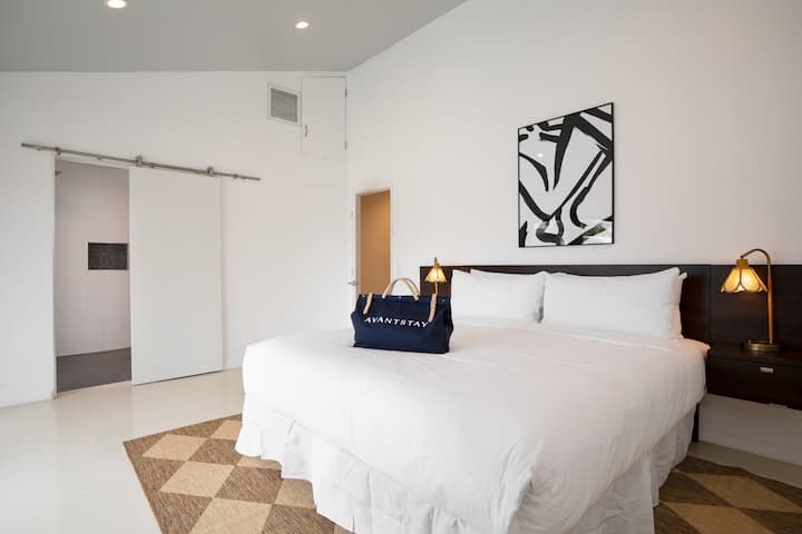 Chumba cha kulala cha msingi kina kitanda aina ya king, runinga na bafu.