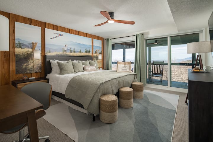 חדר השינה Summer Kites: להירגע עם נופים עוצרי נשימה, מיטת קינג יוקרתית, טלוויין 55 אינץ' של Roku, שולחן עבודה, גישה לסיפון התחתון. ניתן להוציא מזרן זוגי נוסף מתחת למיטת הקינג סייז. איזון מושלם של נוחות ופונקציונליות.