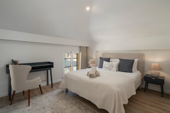 Pokojná spálňa s manželskou posteľou a plyšovou bielou prikrývkou, ktorá je ideálna na oddych v pevnosti Starého Mesta pri Ourmadeire