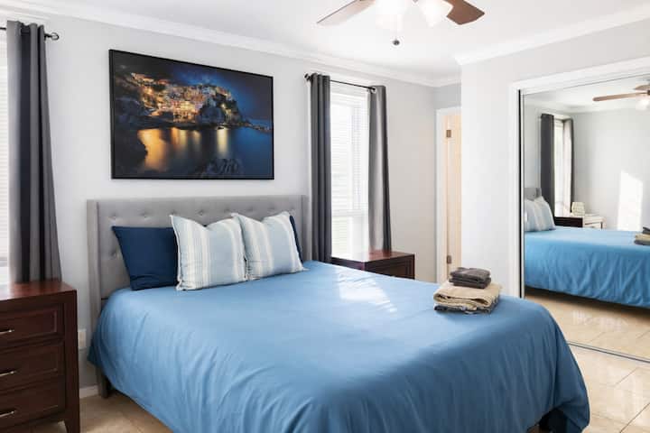 Svijetla i privlačna spavaća soba s udobnim bračnim krevetom, noćnim ormarićima i stropnim ventilatorom. Savršeno mjesto za opuštanje nakon dugog dana.