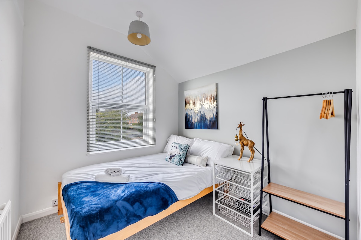 Spavaća soba s udobnim bračnim krevetom s čistom posteljinom i ručnicima.