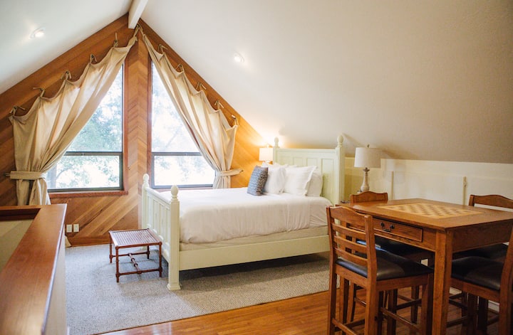 Sunny loft bedroom with treetop views, queen bed + dining/game table