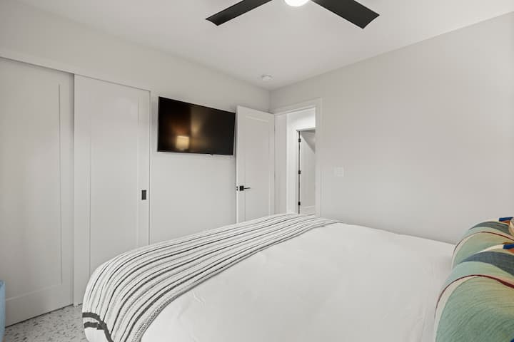 Comfortable queen bedroom with a large TV and garden views