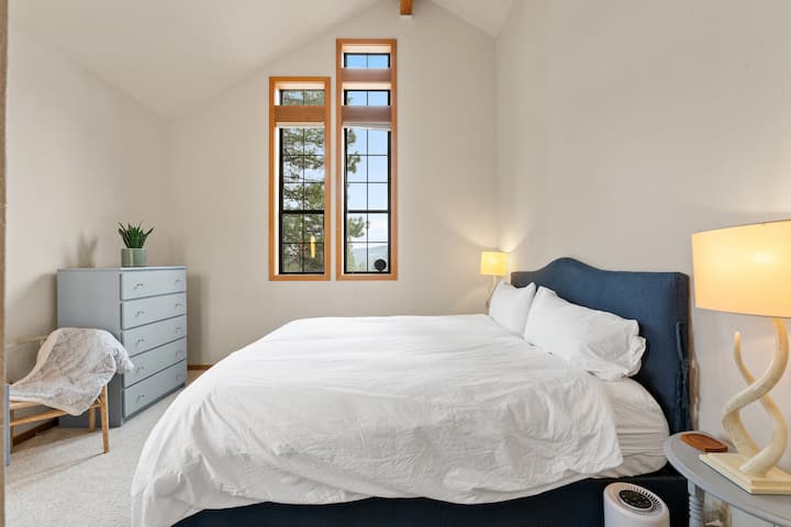 Queen bedroom on the main floor with a dresser and a hand washing sink.
