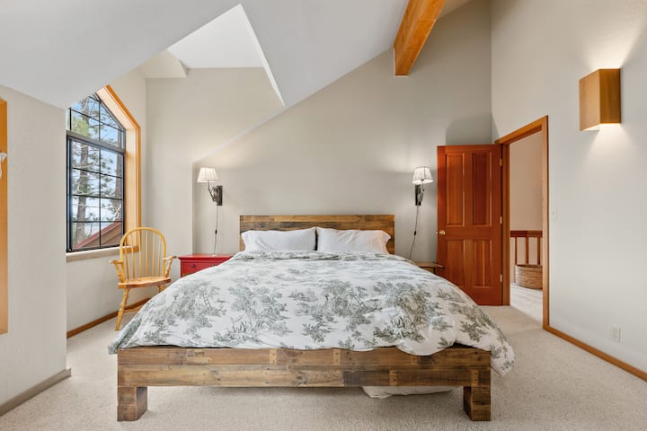 Upstairs primary bedroom with king bed and attached bathroom and workspace.