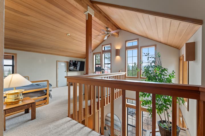 Upstairs loft with a daybed, TV and workspace.