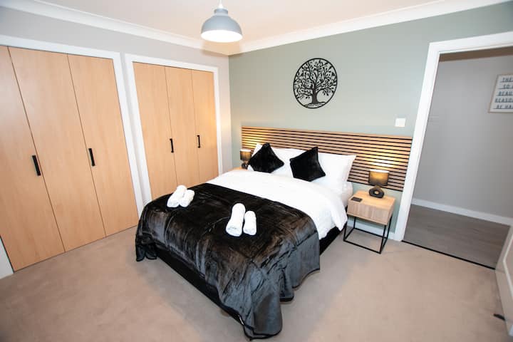 Chambre principale spacieuse avec un lit double confortable, au design moderne et élégant. Ton neutre