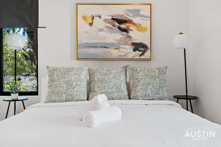 Cama queen size, roupa de cama personalizada e uma configuração que diz "você está sendo cuidado".