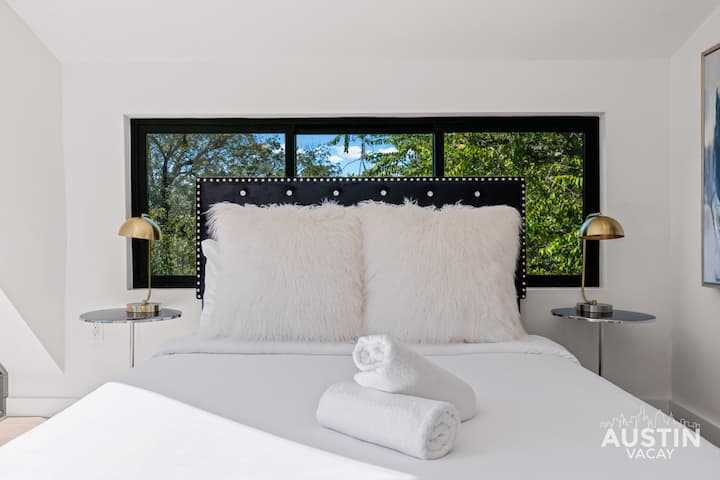 Travesseiros macios, roupas de cama personalizadas de hotel e uma configuração feita para um descanso profundo.
