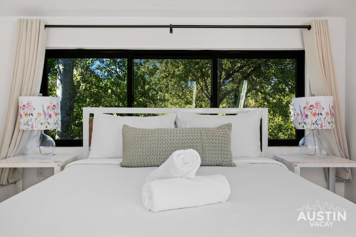 Uma cama queen centrada em lençóis de hotel calmos e personalizados e equilíbrio visual perfeito.