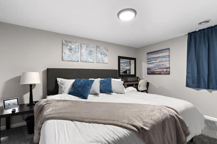 Spálňa na nižšej úrovni: manželská posteľ, HD Roku Smart TV, písací stôl/umývadlo