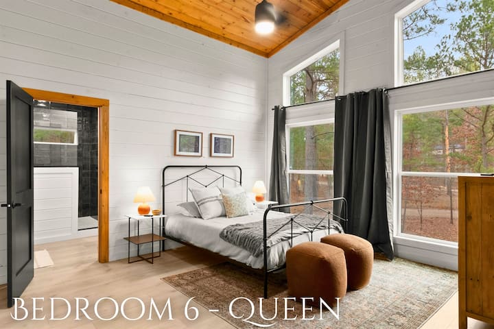 Ეს დედოფლის საძინებელი ქორწინდება ხის სახლის სიმყუდროვეზე თანამედროვე დიზაინის სიცხადით.