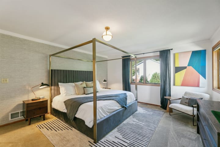 Massive Primary bedroom with King-sized canopy bed. 65" Smart TV, and writing desk.