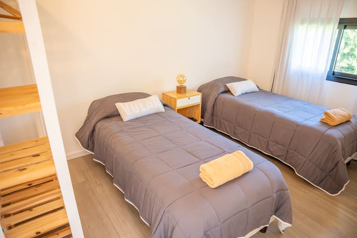 Habitación acogedora con dos camas simples de 1,10 m. Ideal para amigos o familia, ofrece un espacio cómodo y versátil para descansar.