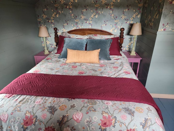 The green bedroom is upstairs and features a queen sized bed.