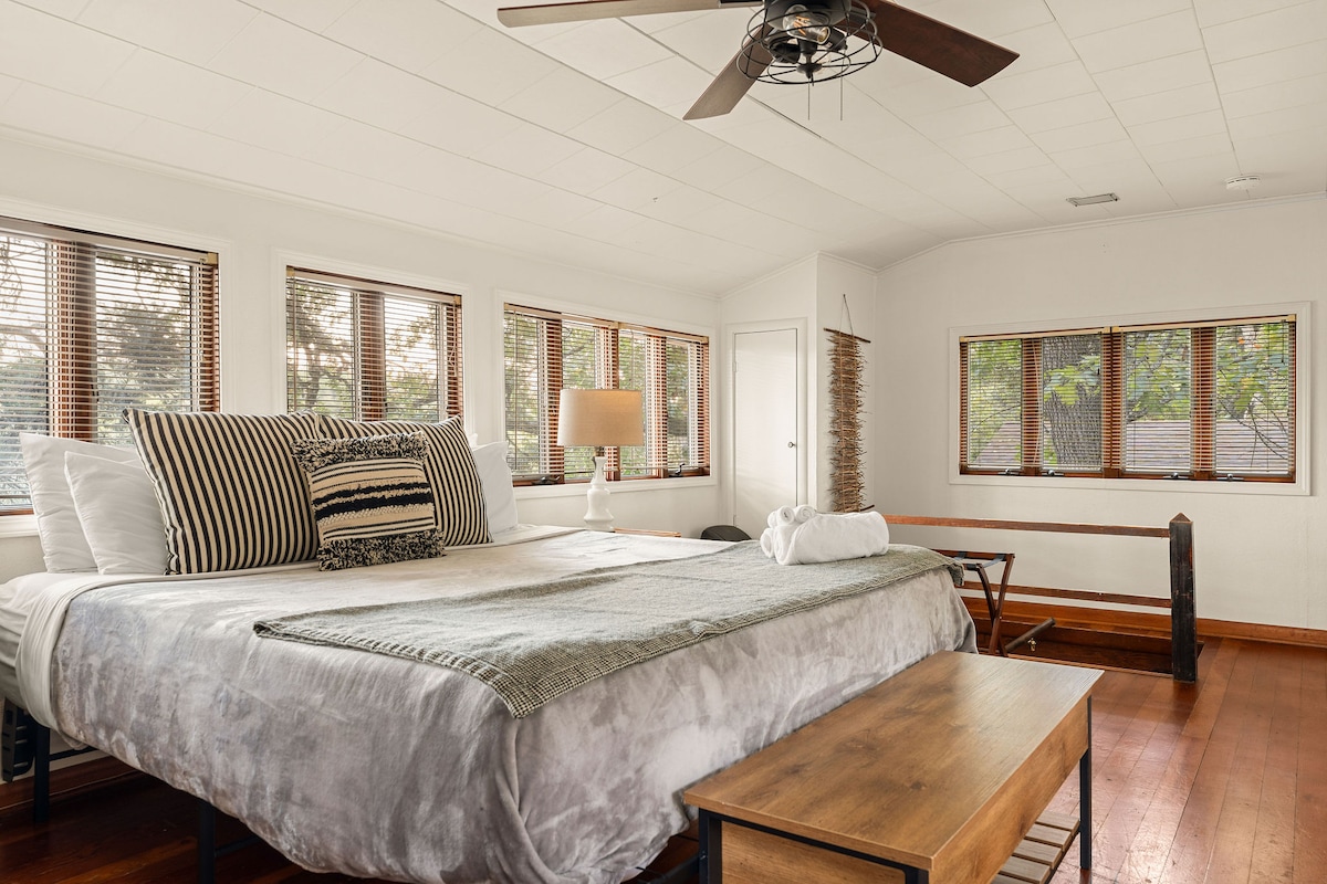 - Просторна спалня, изпълнена с естествена светлина и спокойни тонове
- Зоната за сядане и винтидж тоалетката осигуряват чар, комфорт и полезност
- Дървените подове и широките прозорци създават топло, проветриво и спокойно място за отдих