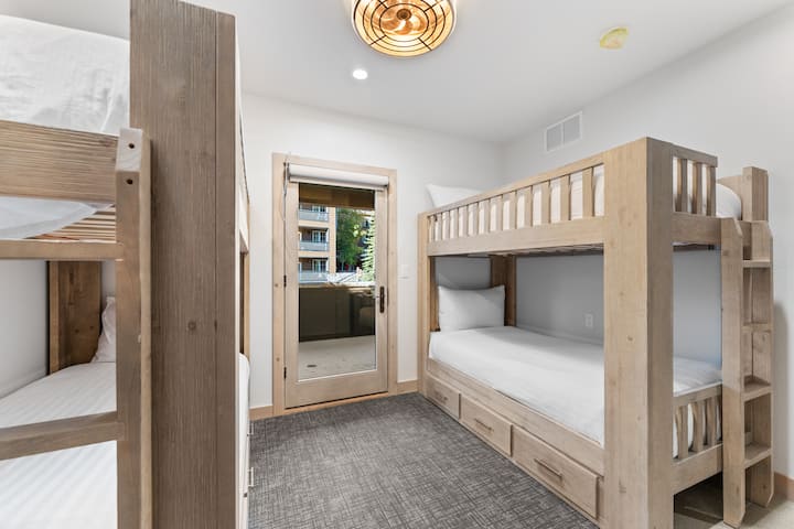 Dormitorio de invitados con dos literas individuales y acceso al balcón. 