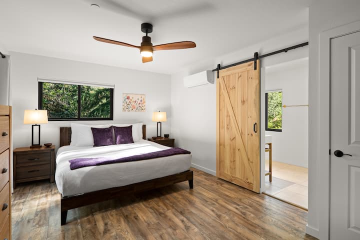 הסוויטה המוארת למעלה מציעה יוקרה של מיטת קינג סייז, כיסא נוח מעור ודלתות פטיו הזזה שנפתחות למרפסת פרטית.