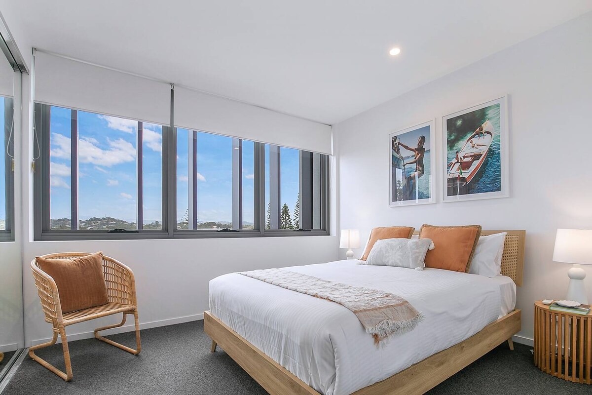 تحتوي غرفة النوم الثانية الخفيفة ذات الهواء الطلق على سرير متوسط الحجم ونوافذ من الجدار إلى الجدار تغمر المسكن بالضوء الطبيعي. يوفر الروب المدمج المعكوس بمساحة تخزين واسعة.