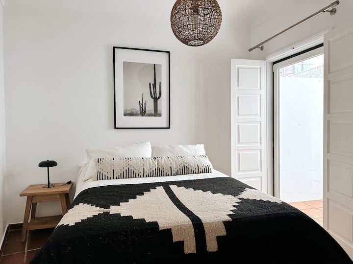 Dhoma e dytë e gjumit në Casa Palo Verde në The Blanco Bungalow Ericeira me një krevat King Size me dyshek krejt të ri, shtroja krevati premium të lara në detergjent me bazë bimore, gardërobë dhe oborr privat. @blancobungalow