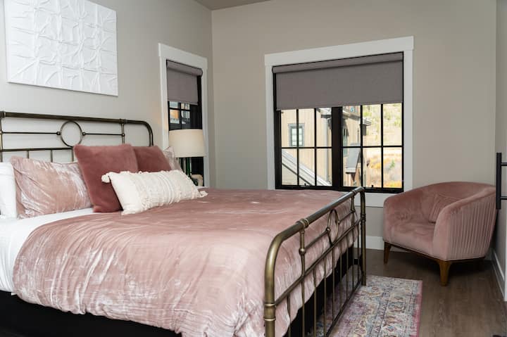 - ห้องนอนพร้อมเตียงที่มีโครงเตียงทองเหลือง เครื่องนอนสีชมพูและเก้าอี้ที่เข้ากันอยู่ที่มุมห้อง
- หน้าต่างบานใหญ่พร้อมม่านบังแสงให้ทั้งแสงธรรมชาติและความเป็นส่วนตัว
- ที่พักที่อบอุ่นและมีสไตล์เหมาะสำหรับการพักผ่อนหลังจากทำกิจกรรมมาทั้งวัน